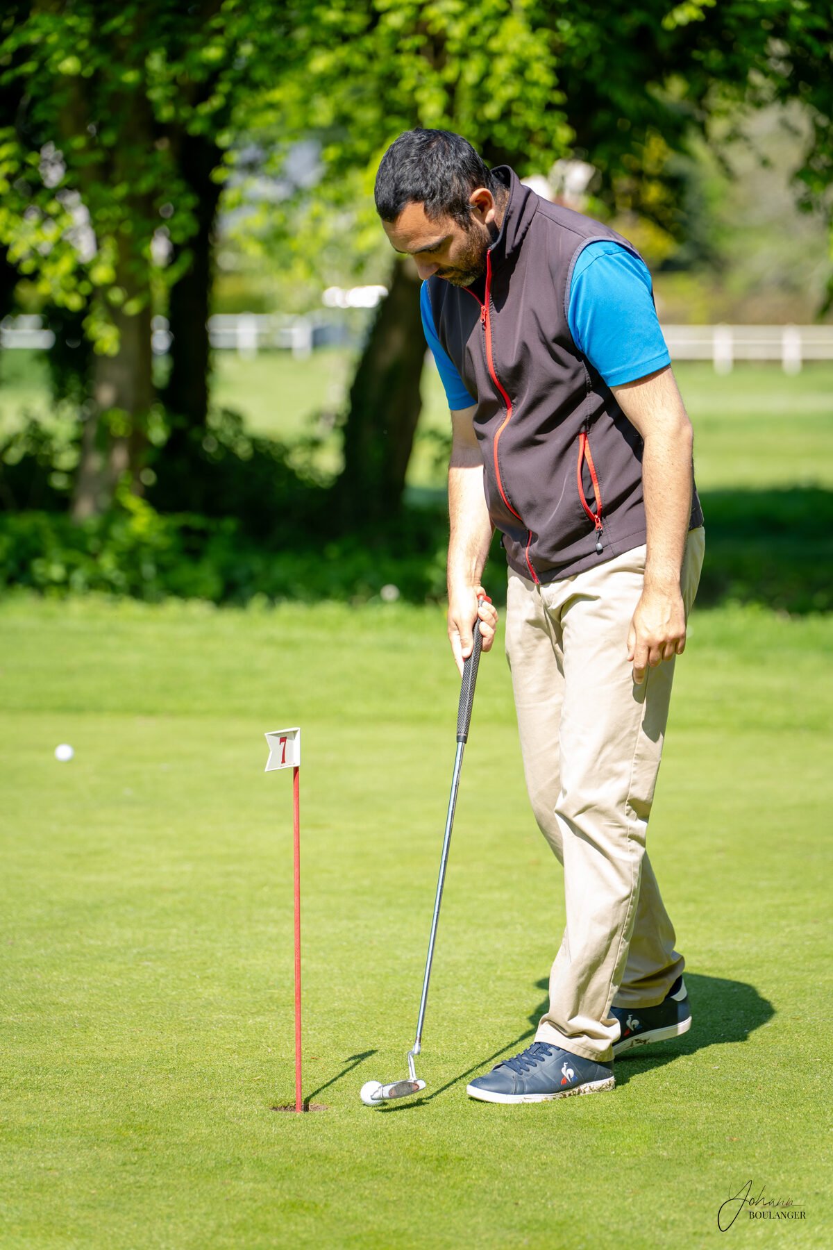 Homme concentré jouant au golf sur un green ensoleillé