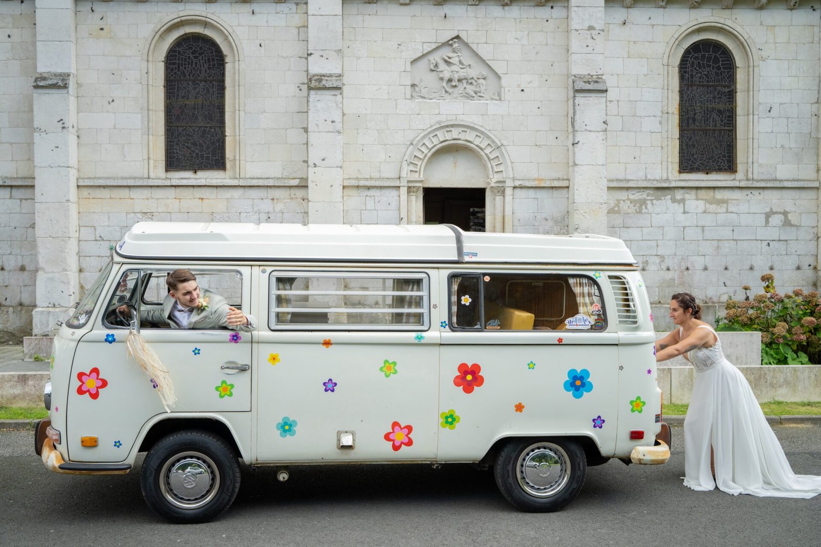 La mariée pousse un van décoré pendant que le marié est au volant.