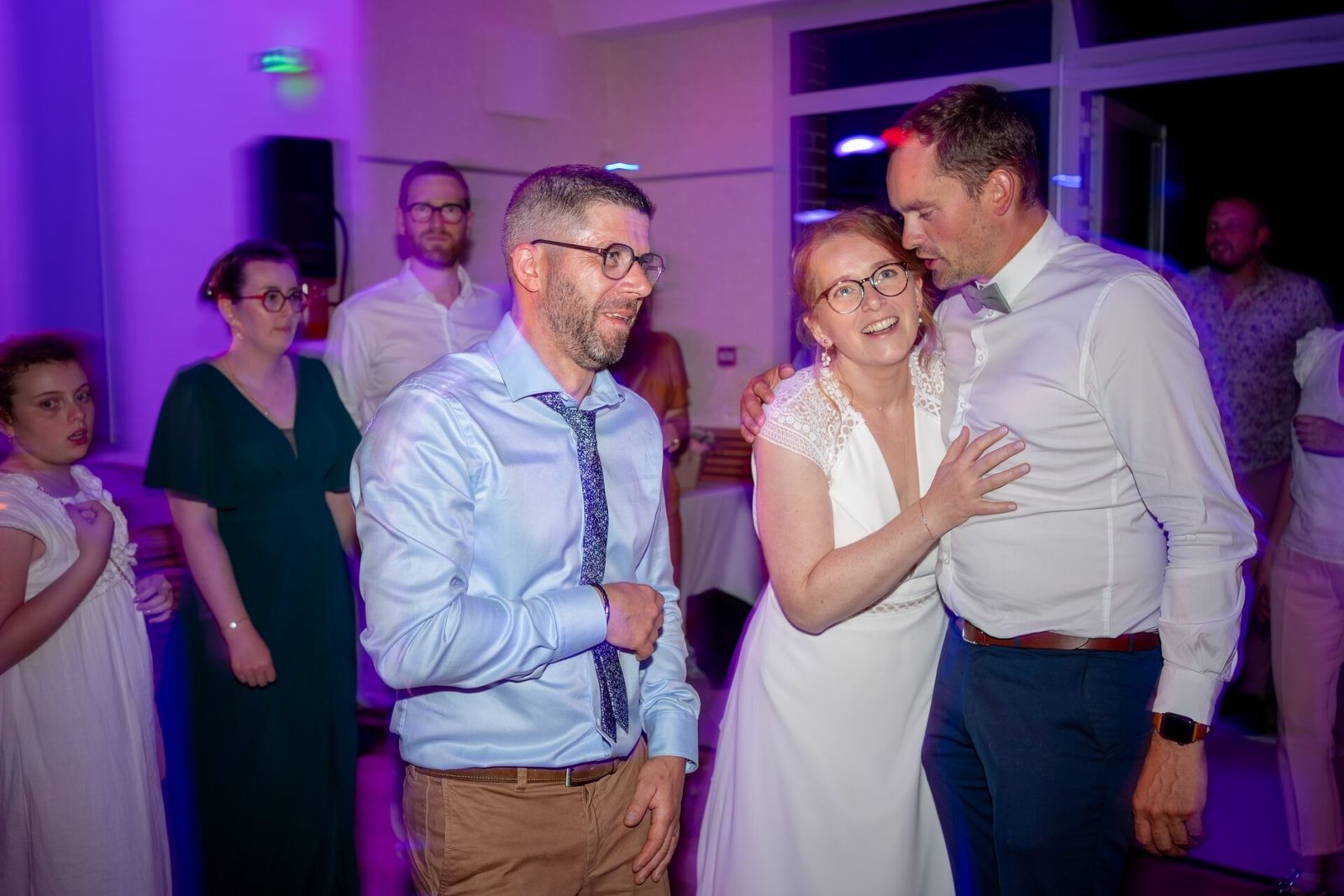 Ambiance festive en soirée de mariage avec les mariés et leurs invités sur la piste de danse.