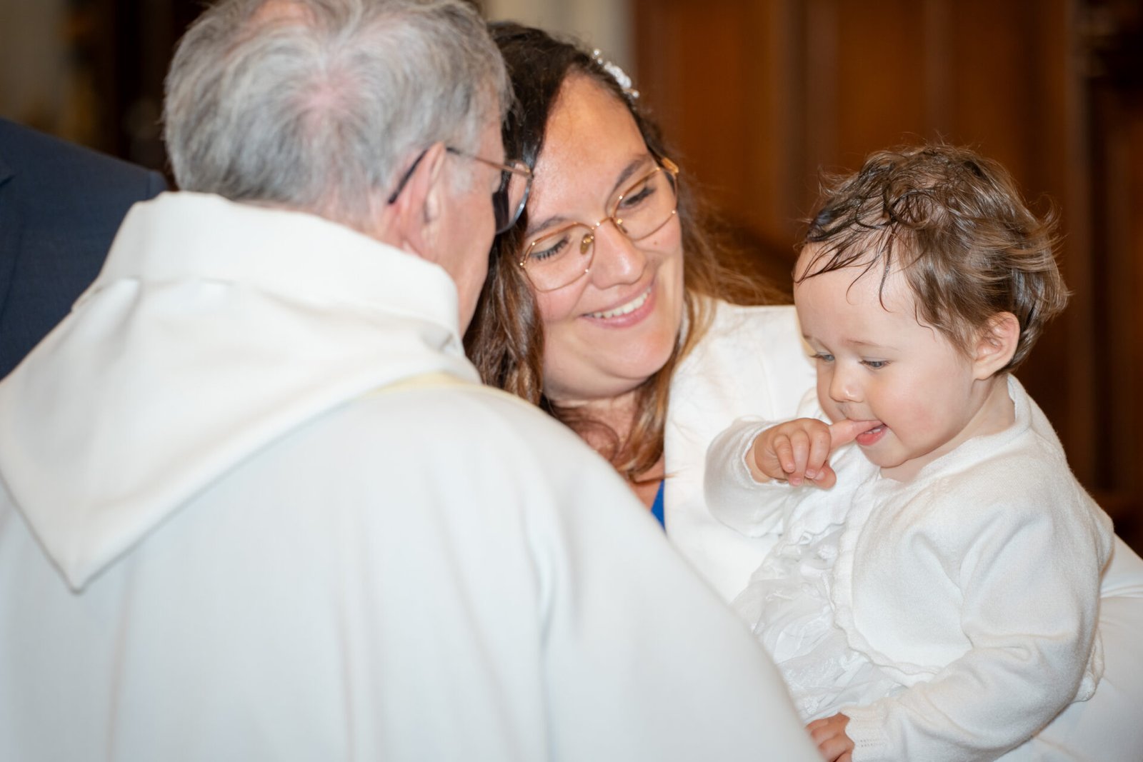 Photographe de baptême à Grand Bourgtheroulde – moment tendre entre la maman et son enfant après la cérémonie.
